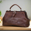 Load image into Gallery viewer, Brown leather handbag on a light wooden surface with a neutral background