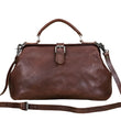 Load image into Gallery viewer, Brown leather handbag with a strap on a light wooden surface