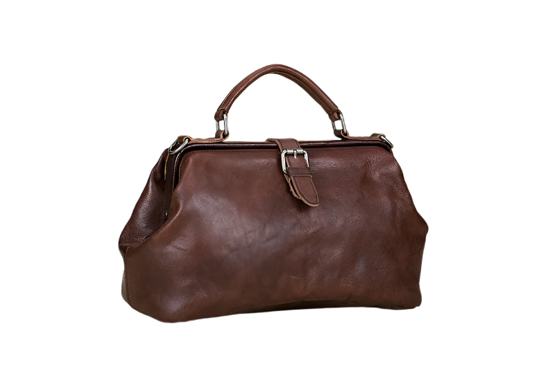 Brown leather handbag on a light wooden surface