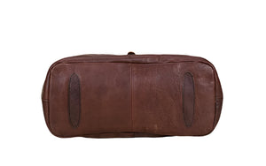 Brown leather duffel bag on a light wooden surface