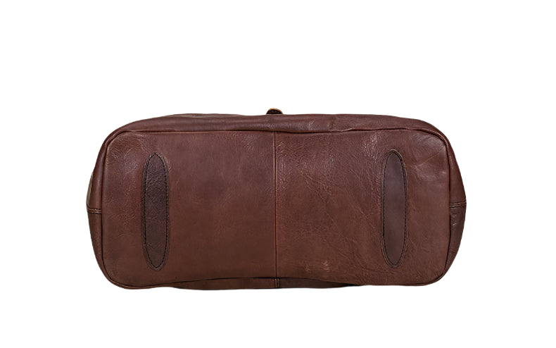 Brown leather duffel bag on a light wooden surface