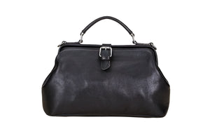 Black leather handbag on a light wooden surface