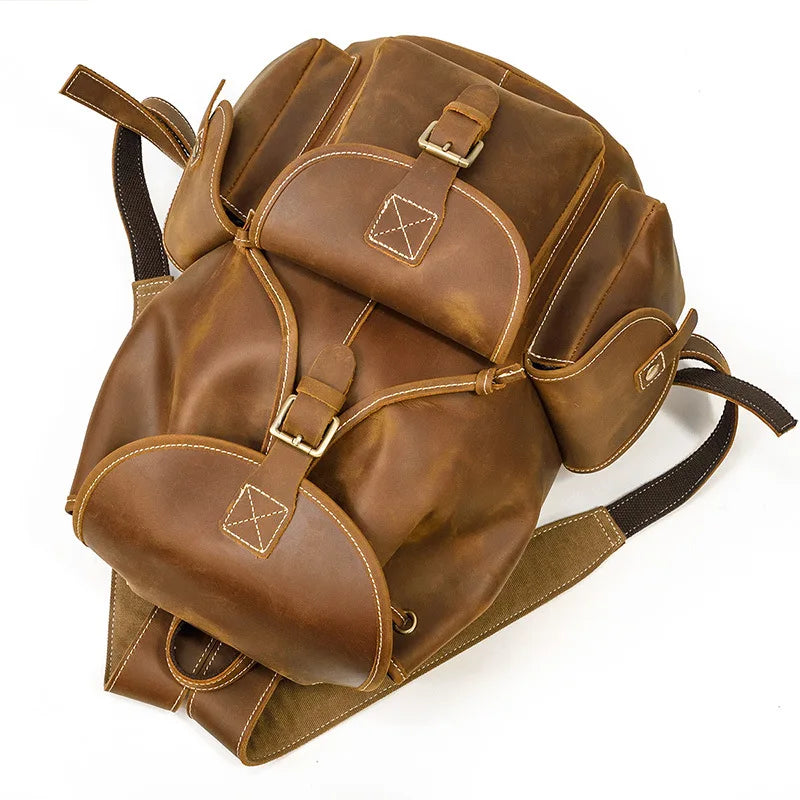 Brown leather backpack with gold accents on a white background