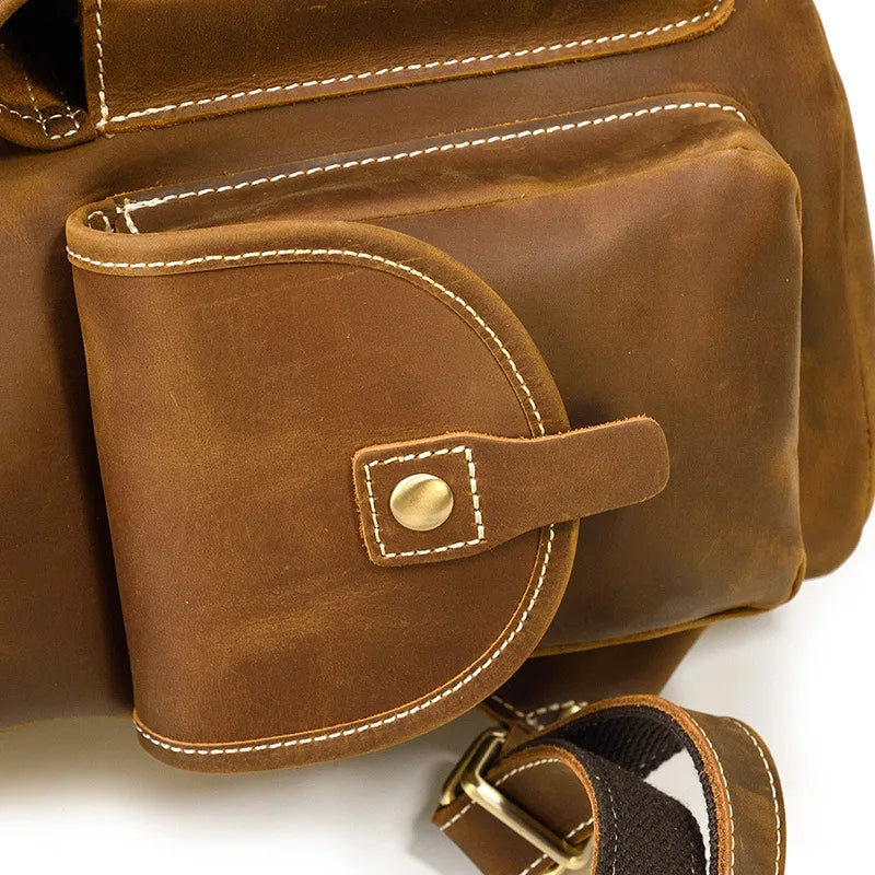 Close-up of a brown leather bag with a strap and buckle on a white background