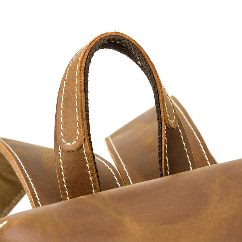Close-up of a brown leather bag with visible stitching on a white background