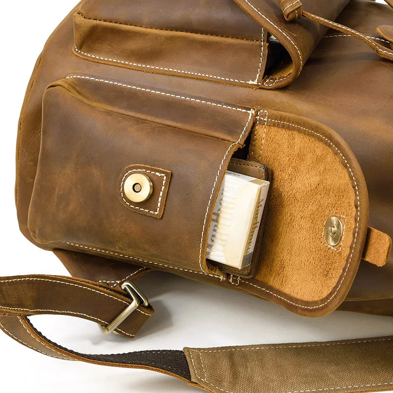 Brown leather bag with a pocket open, showing a white paper inside, on a white background